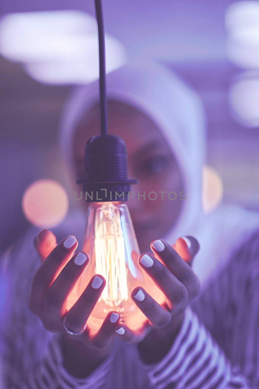 internet of things concept woman holding hands around bulb by dotshock