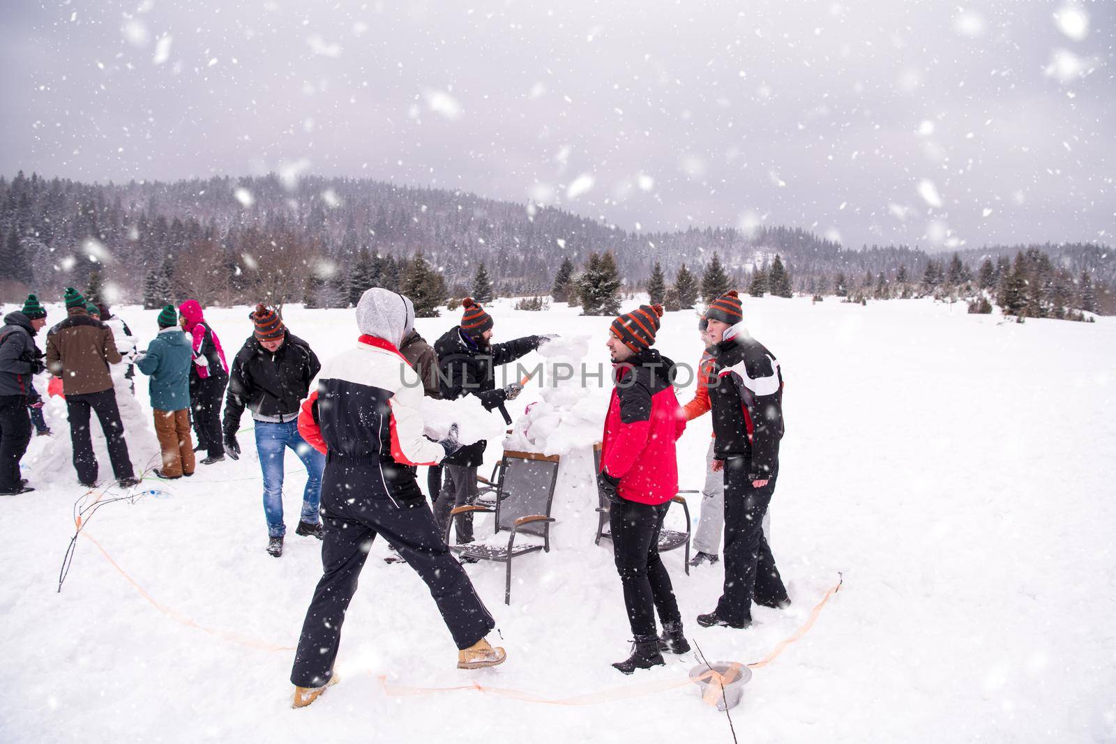 group of young people making a snowman by dotshock