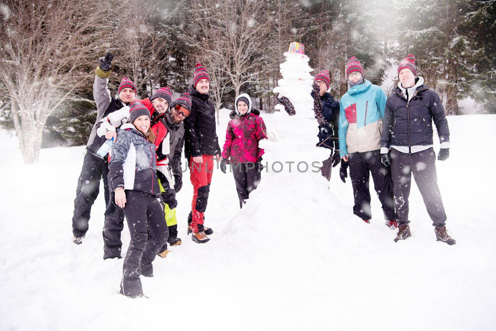 group portait of young people posing with snowman by dotshock