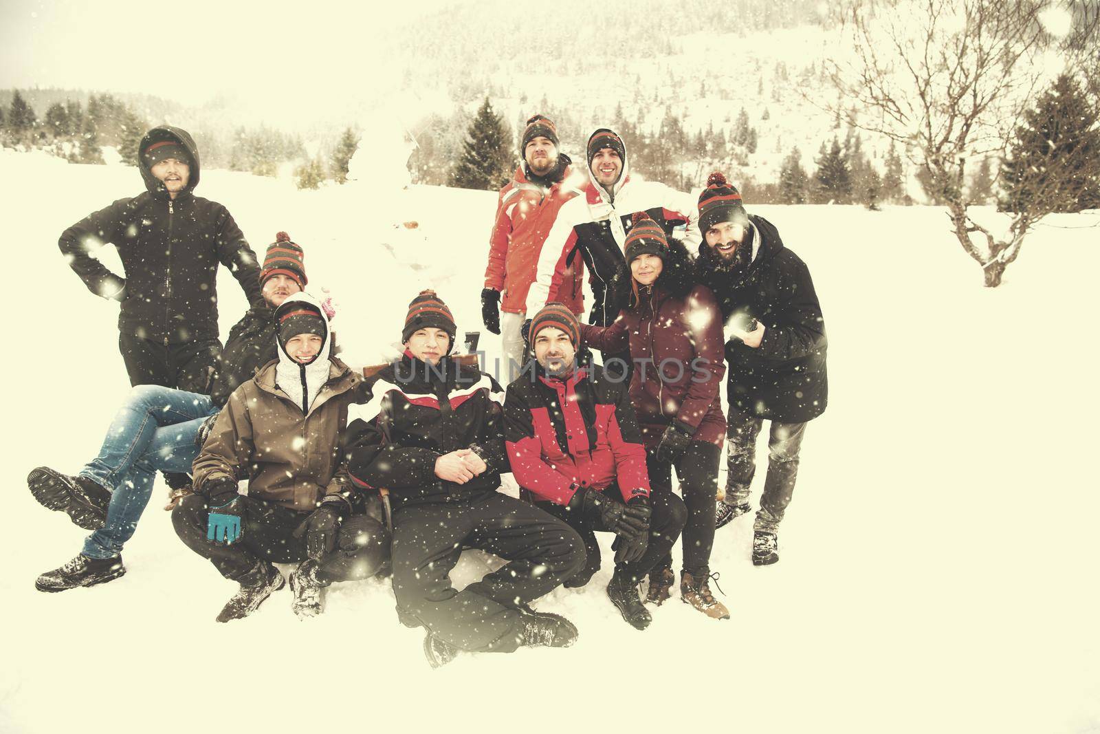 group portait of young people posing with snowman by dotshock