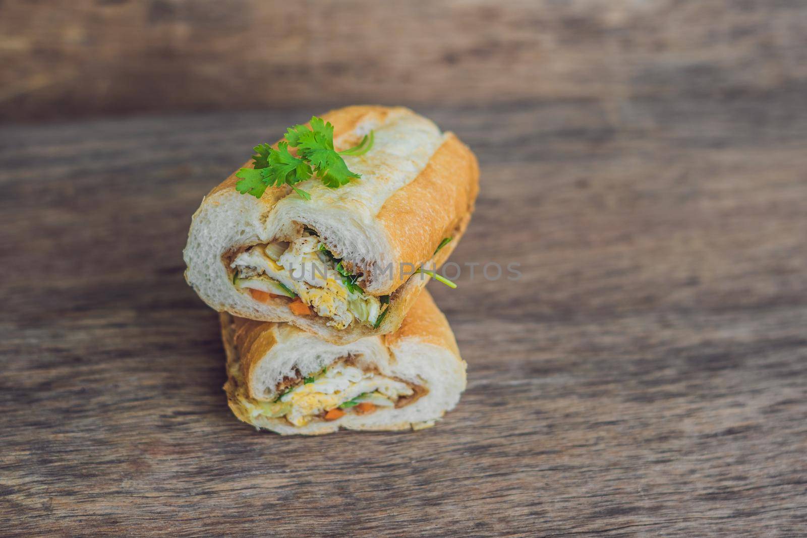 A delicious Vietnamese Bahn Mi sandwich on a wooden background by galitskaya