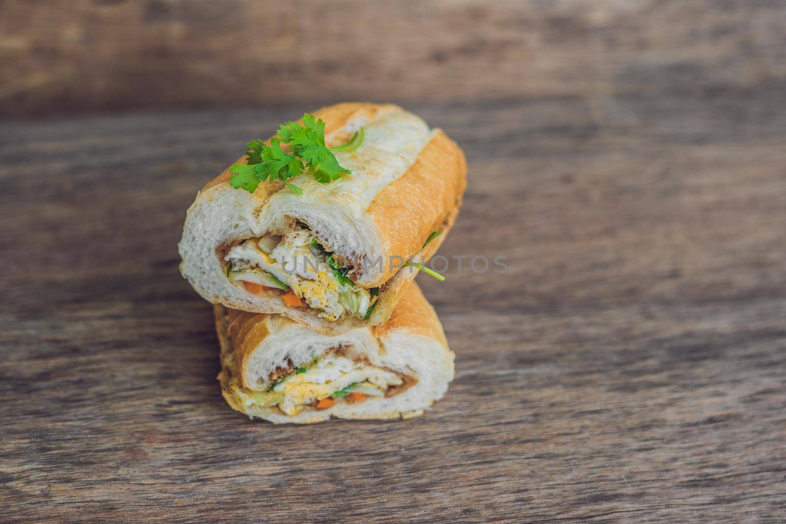 A delicious Vietnamese Bahn Mi sandwich on a wooden background.