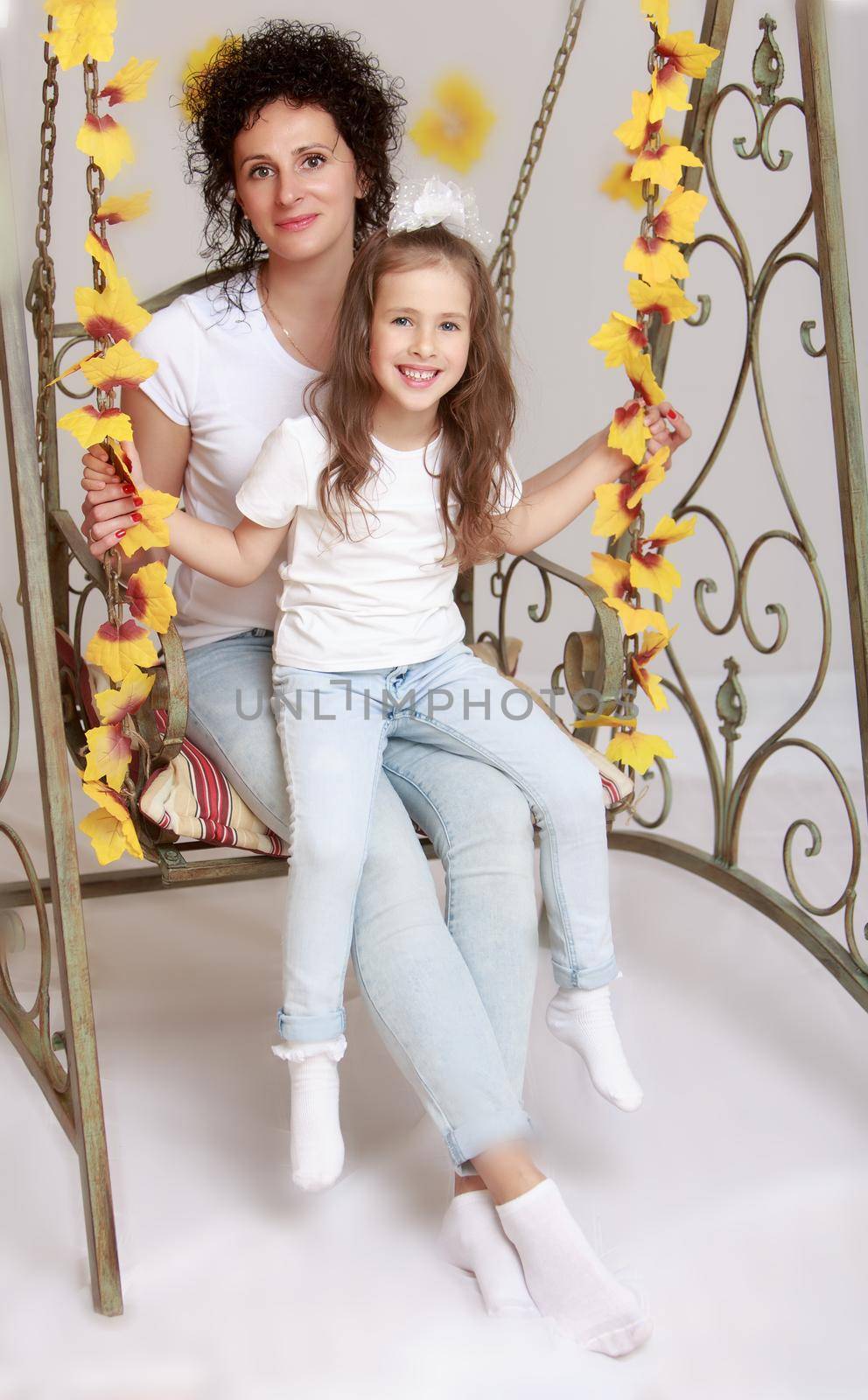 Daughter and mom swinging on the swings by kolesnikov_studio