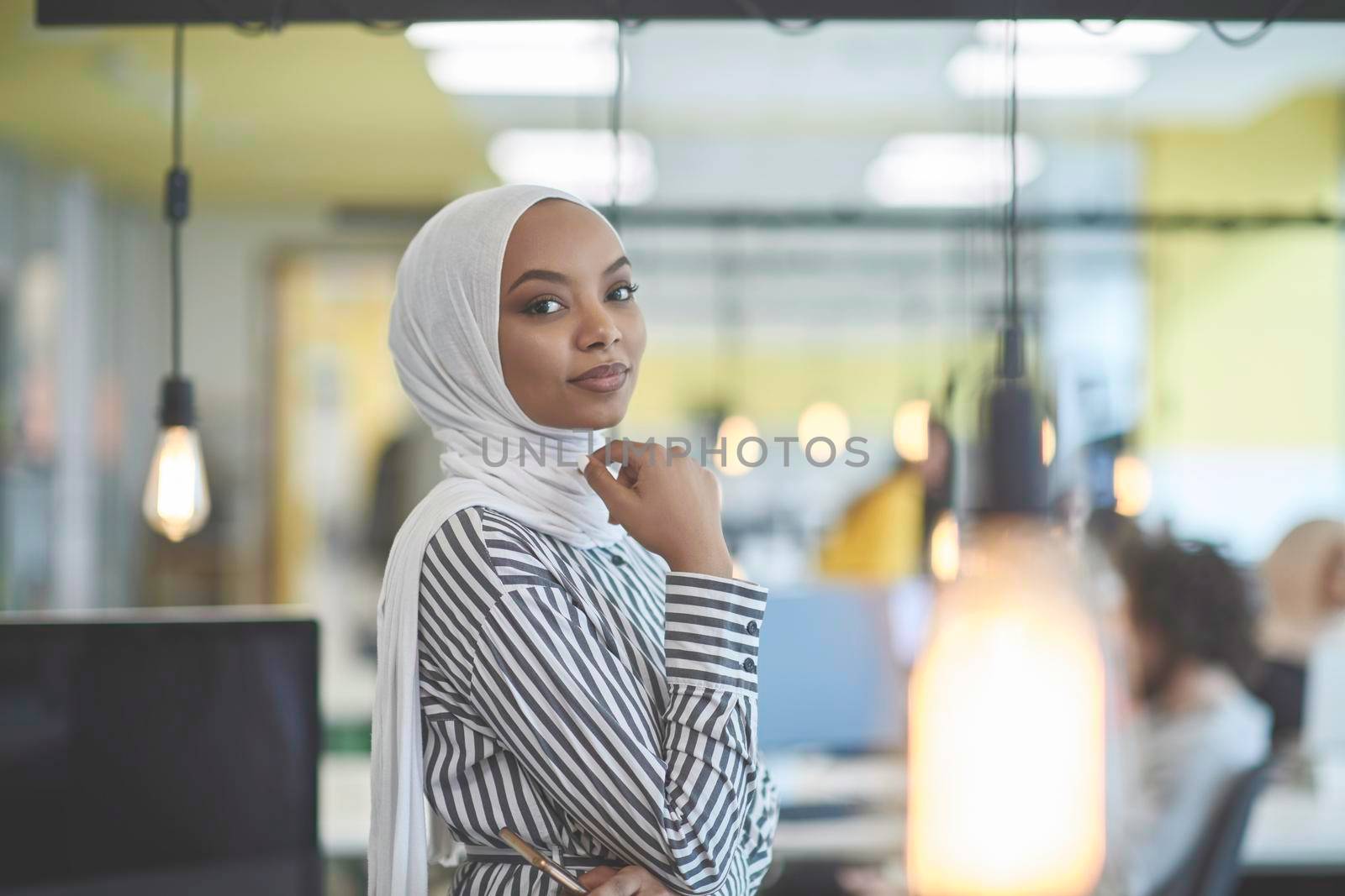 beautiful modern african Muslim businesswoman in office, wearing hijab at creative modern startup coworking space