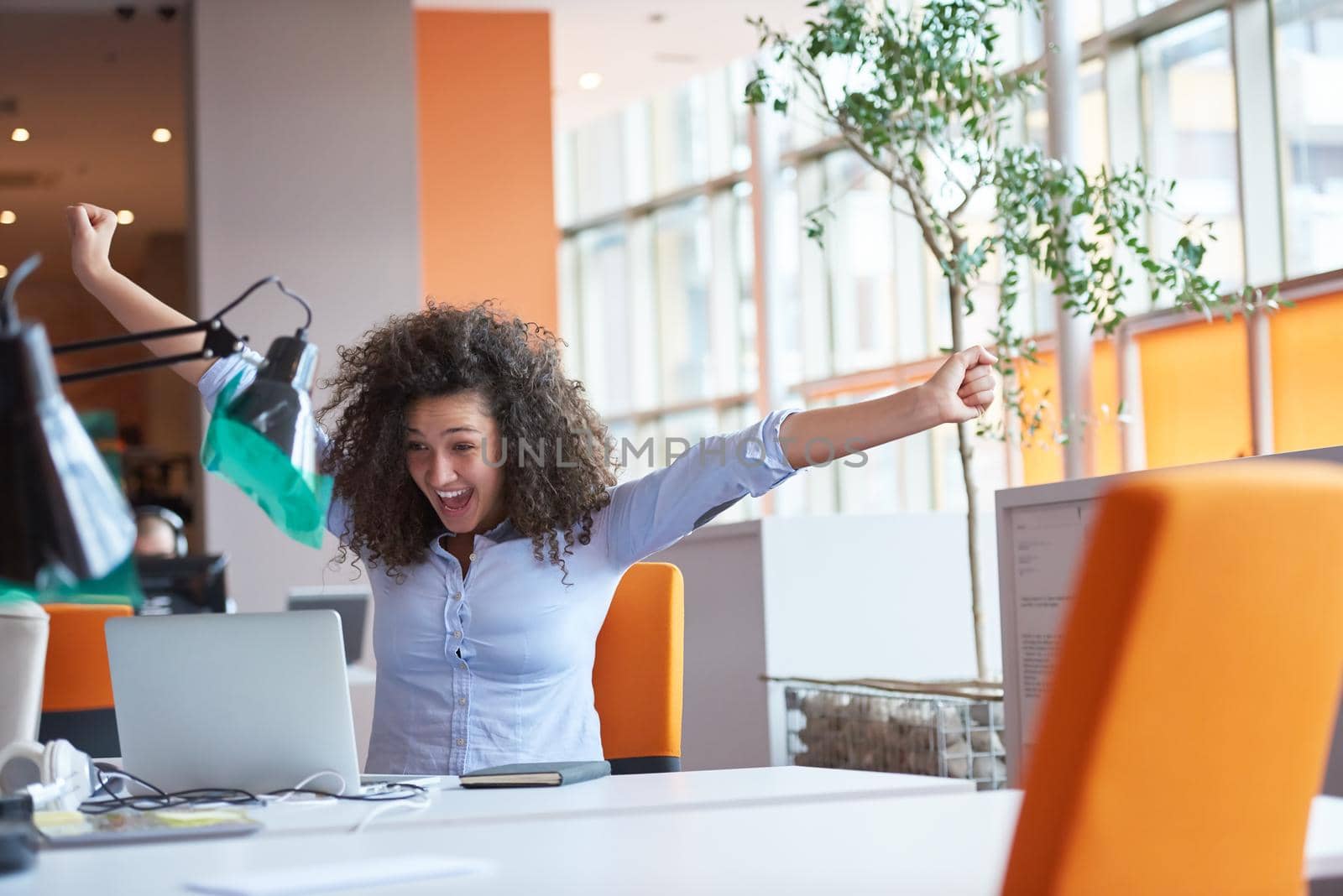 happy young  business woman with curly hairstyle in the modern office