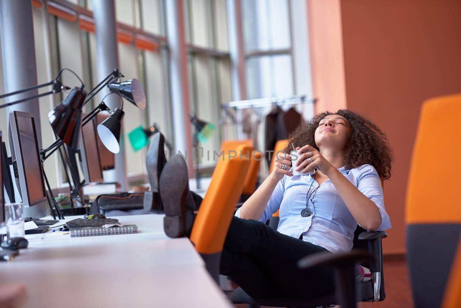 happy young  business woman with curly hairstyle in the modern office