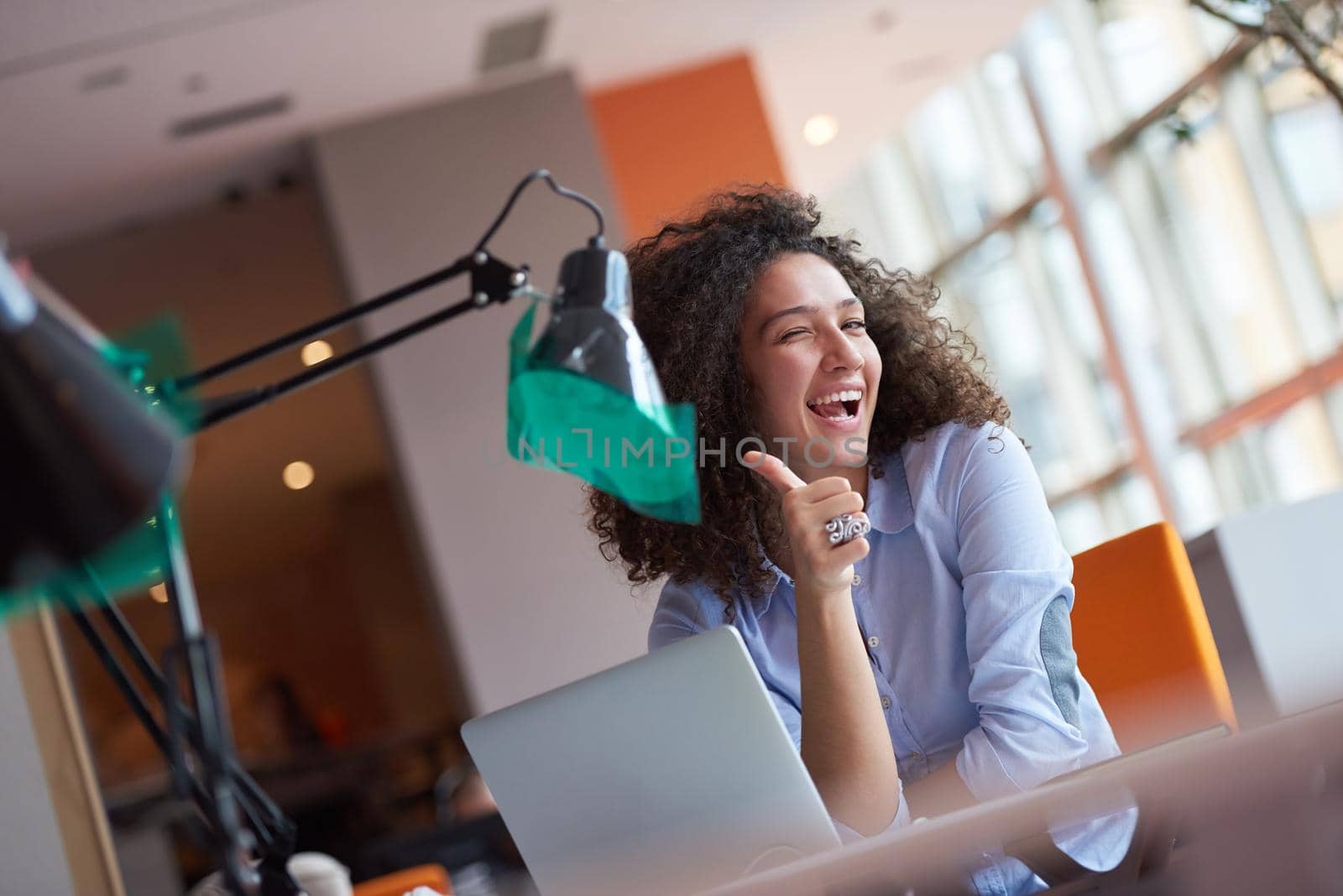 happy young  business woman with curly hairstyle in the modern office