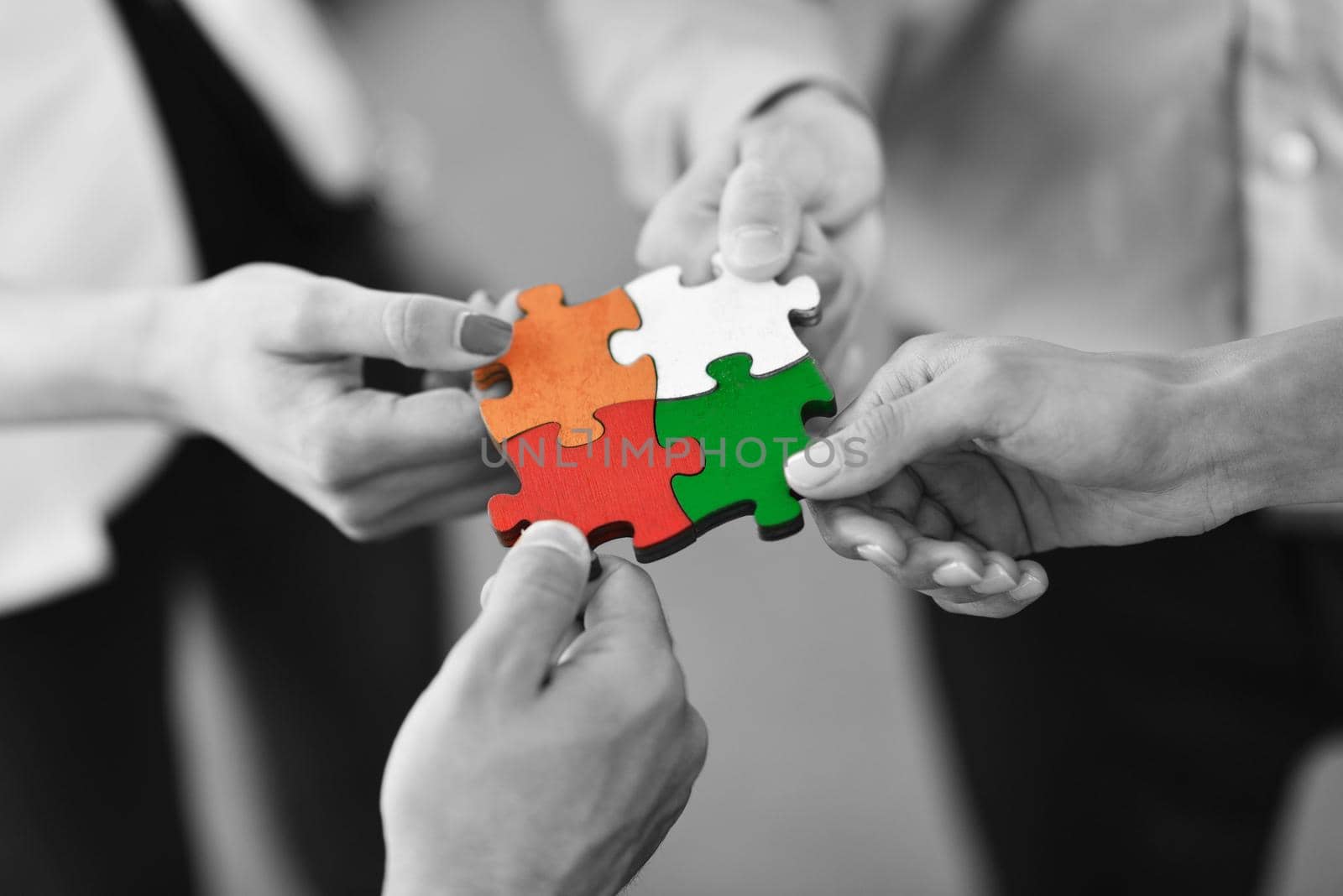 Group of business people assembling jigsaw puzzle by dotshock