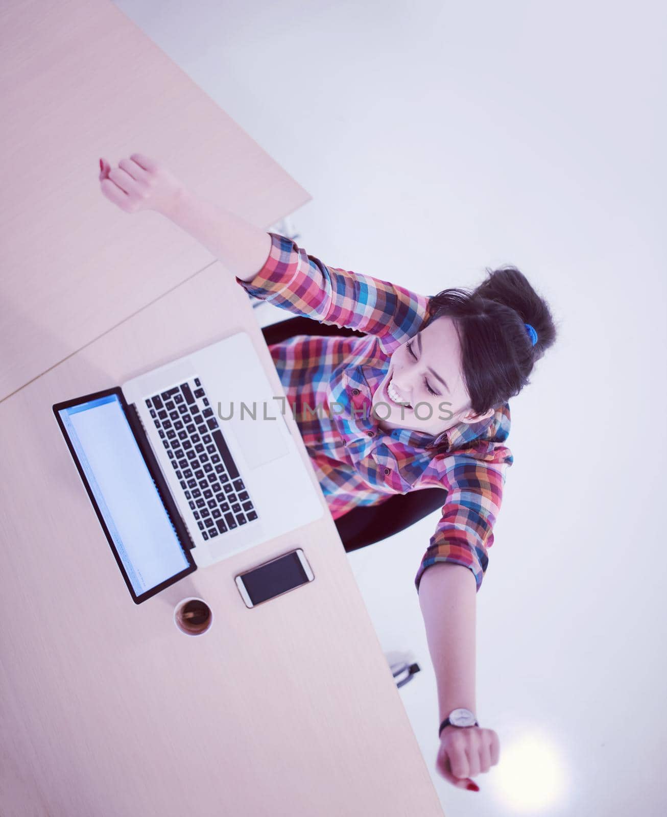 top view of young business woman working on laptop computer in modern bright startup office interior