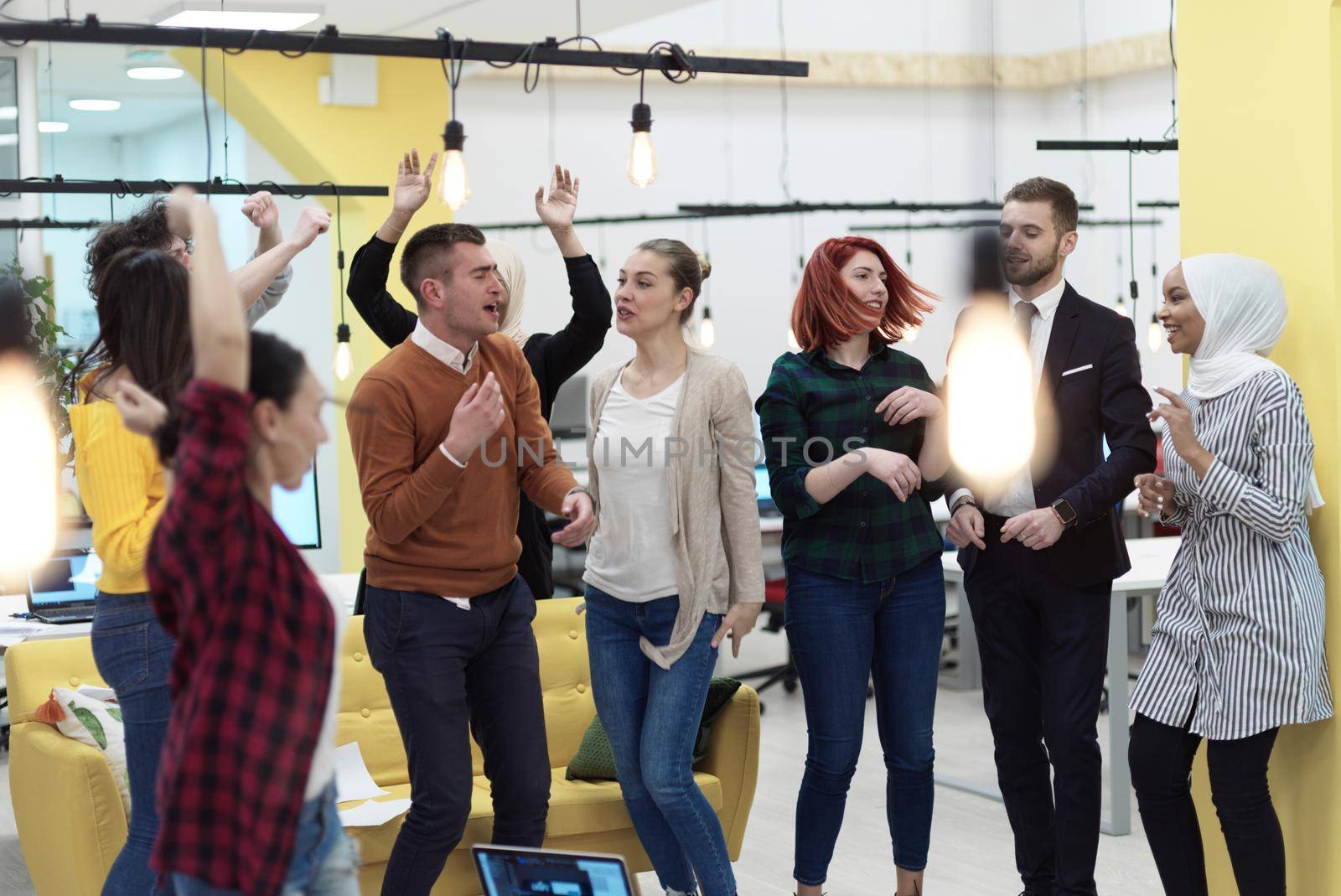 Group of business people having party and  throwing paper in air at modern coworking open space  startup office