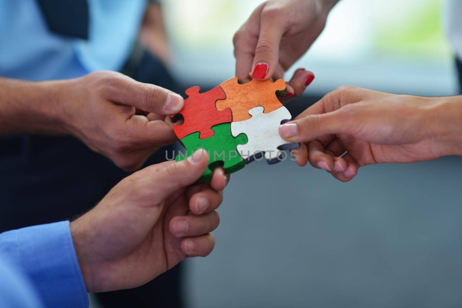 Group of business people assembling jigsaw puzzle by dotshock