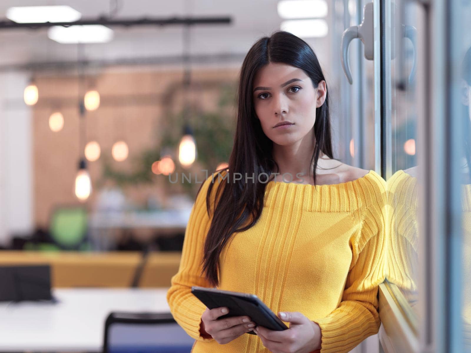 business woman portrait  in open space startup coworking office as influencer  using smart phone, tablet computer