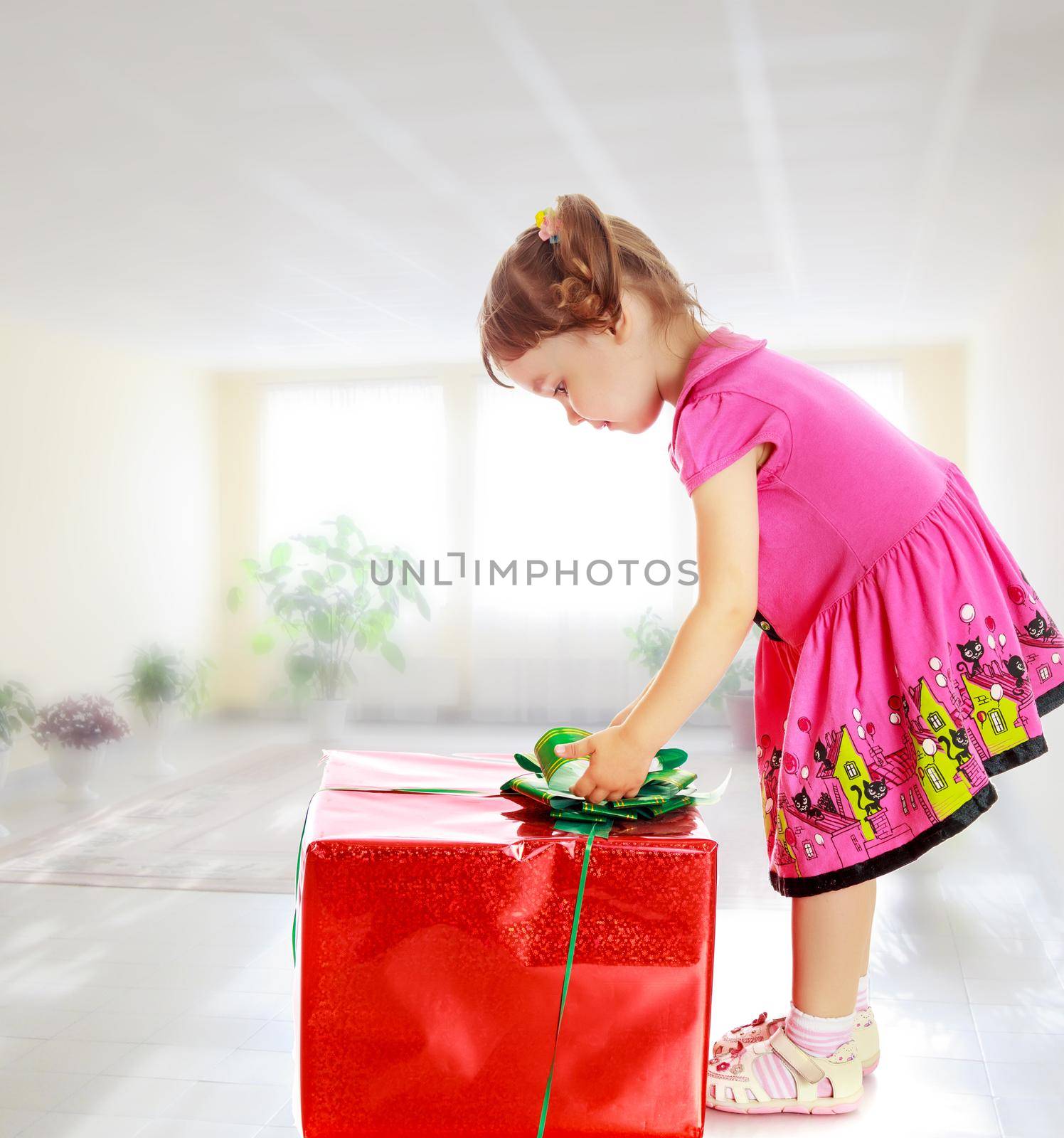 Little girl looking at a gift by kolesnikov_studio