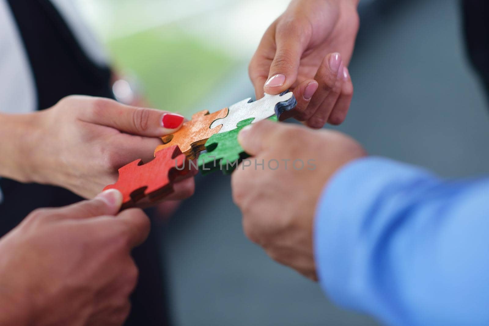 Group of business people assembling jigsaw puzzle and represent team support and help concept