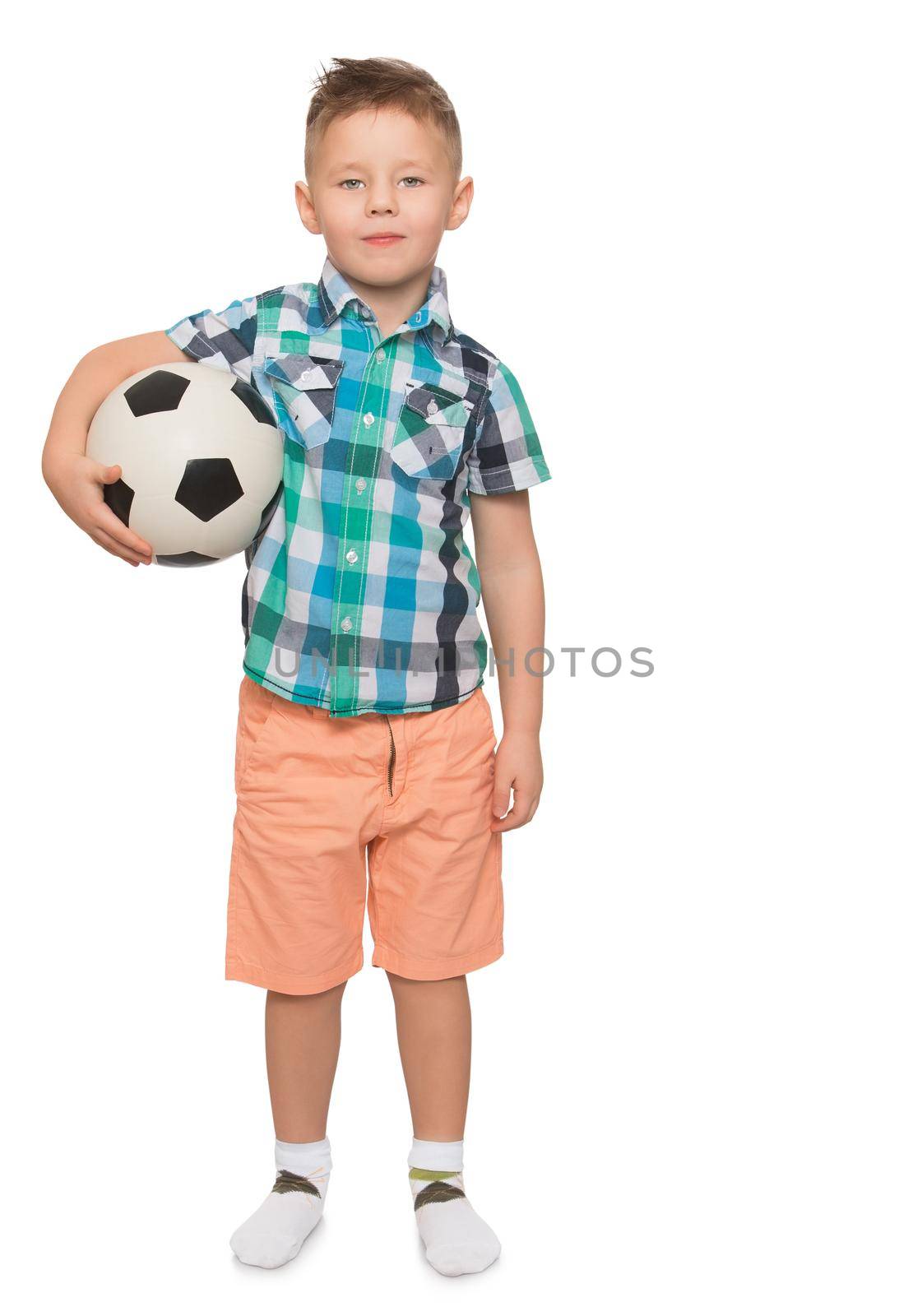 Beautiful little boy with a fashionable hairstyle on the head . The boy is holding under one arm a football . Portrait in full growth - Isolated on white background