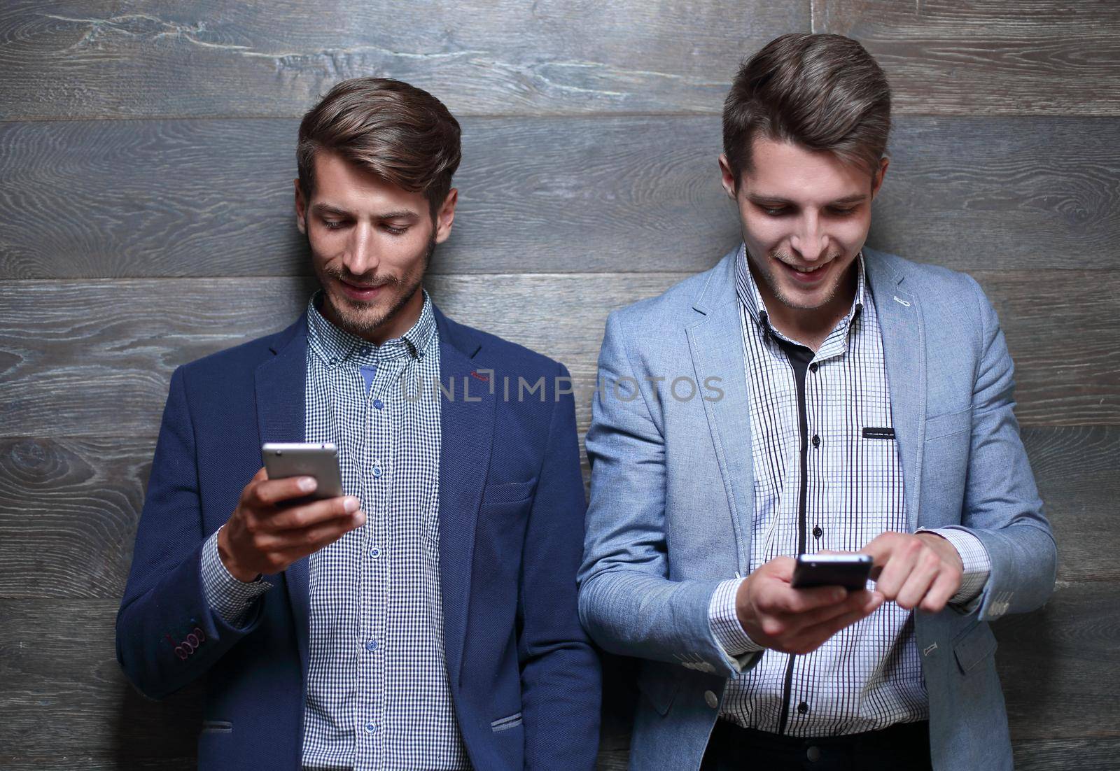 entrepreneurs hold smartphones in their hands and smile
