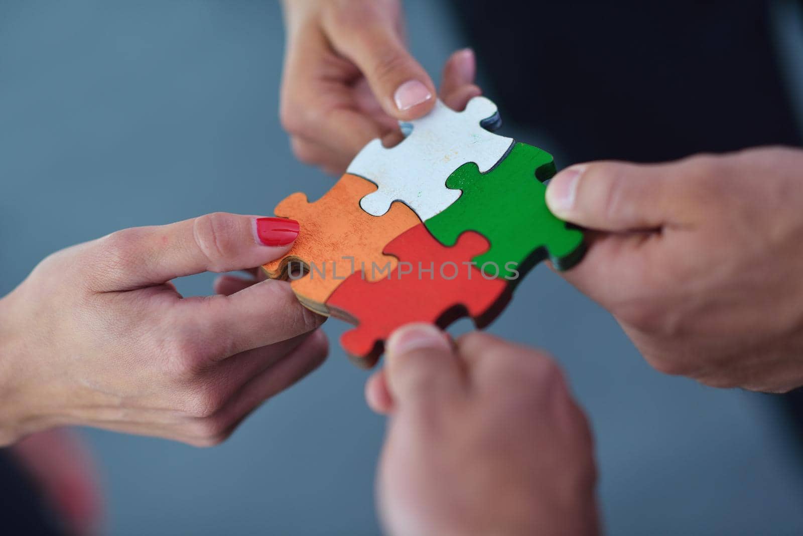 Group of business people assembling jigsaw puzzle by dotshock