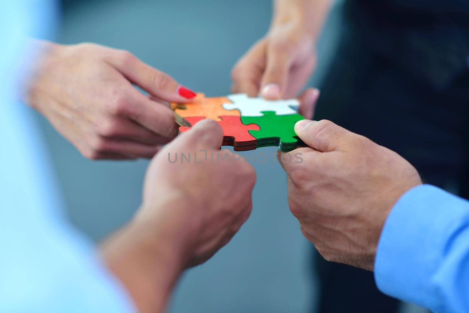 Group of business people assembling jigsaw puzzle and represent team support and help concept