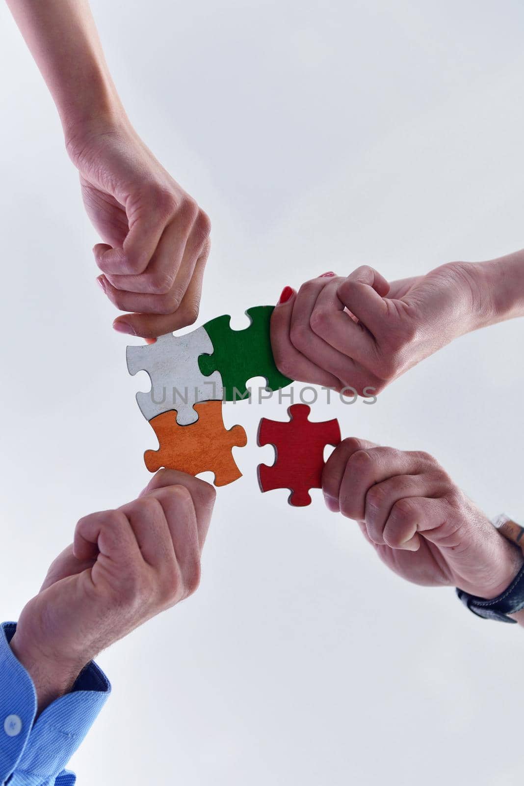 Group of business people assembling jigsaw puzzle by dotshock