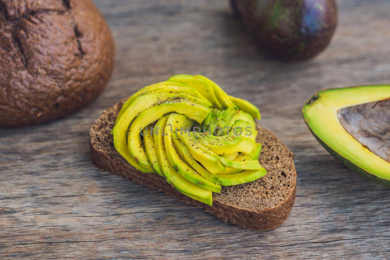 Avocado sandwich on dark rye bread made with fresh sliced avocados.