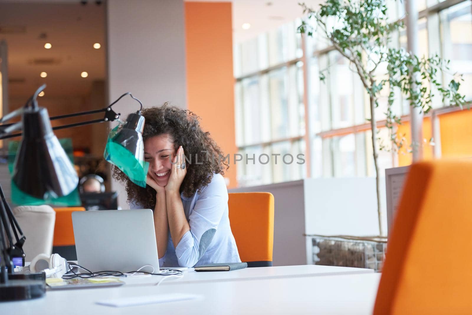 happy young  business woman with curly hairstyle in the modern office