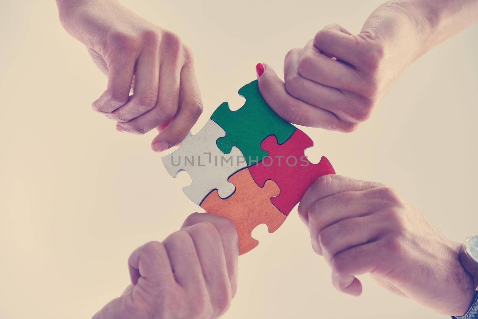 Group of business people assembling jigsaw puzzle by dotshock