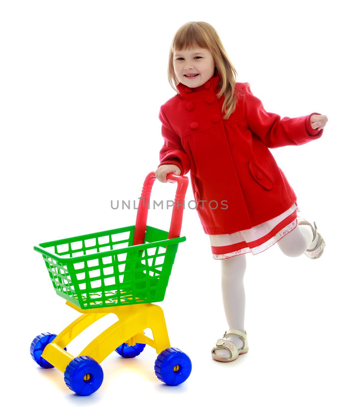 Cute little girl in a red coat, with a toy shopping cart.Isolated on white background.1
