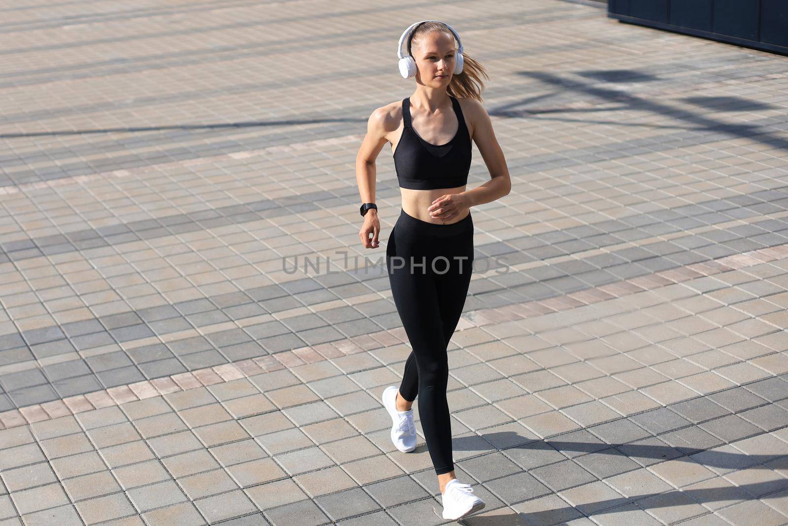 Young attractive woman with perfect slim body running outdoors. Fitness and running concept. by tsyhun