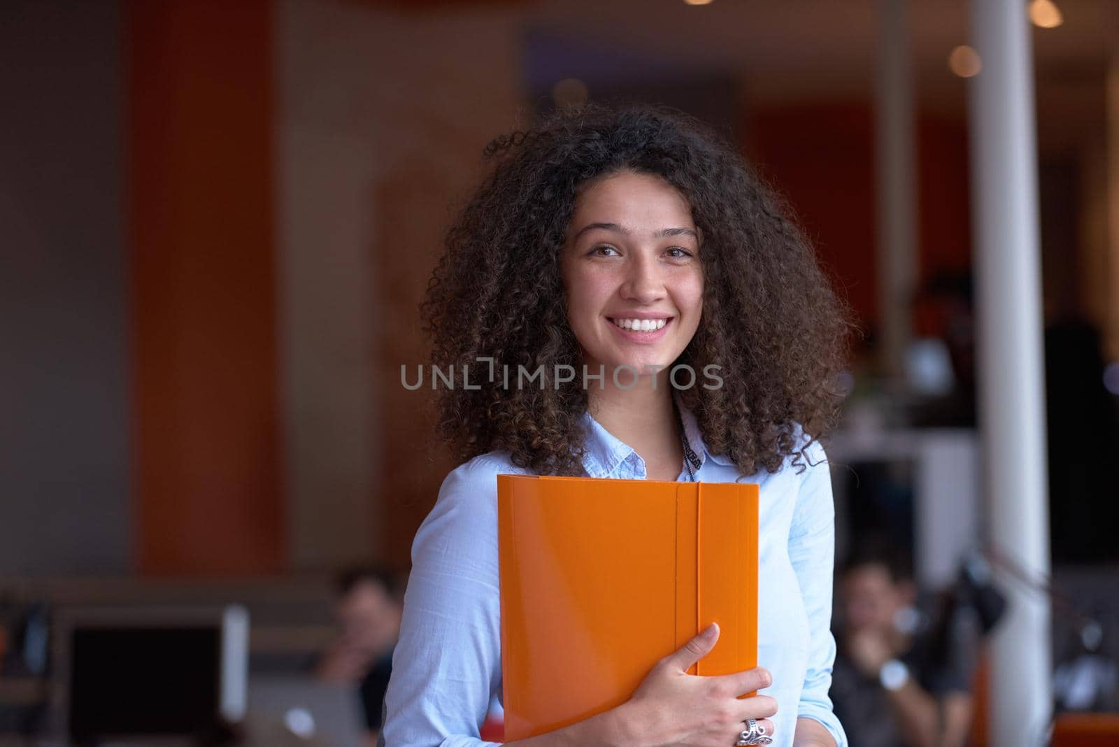 happy young  business woman with curly hairstyle in the modern office