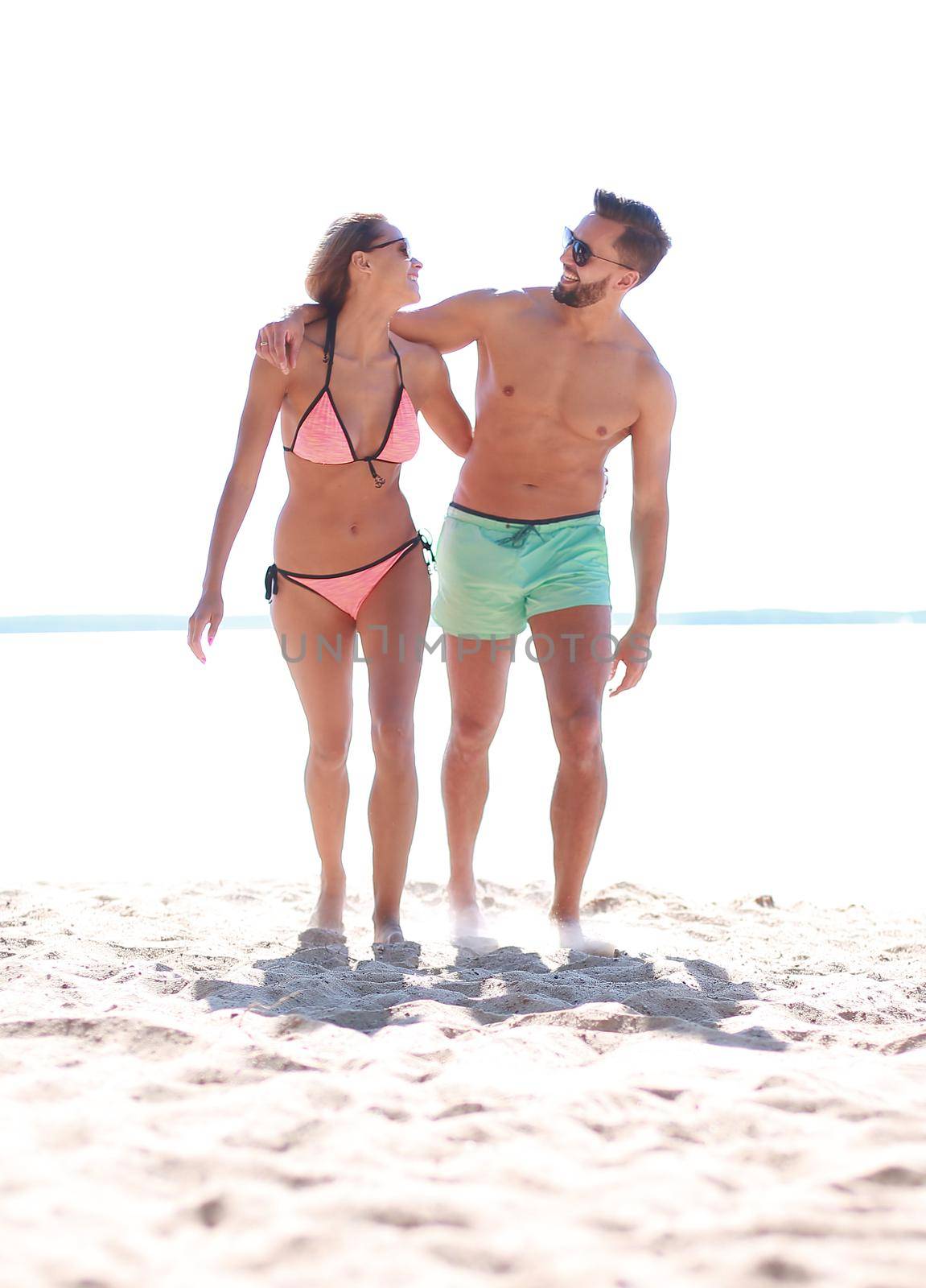 Happy fun beach vacations couple walking together laughing having fun on travel destination.