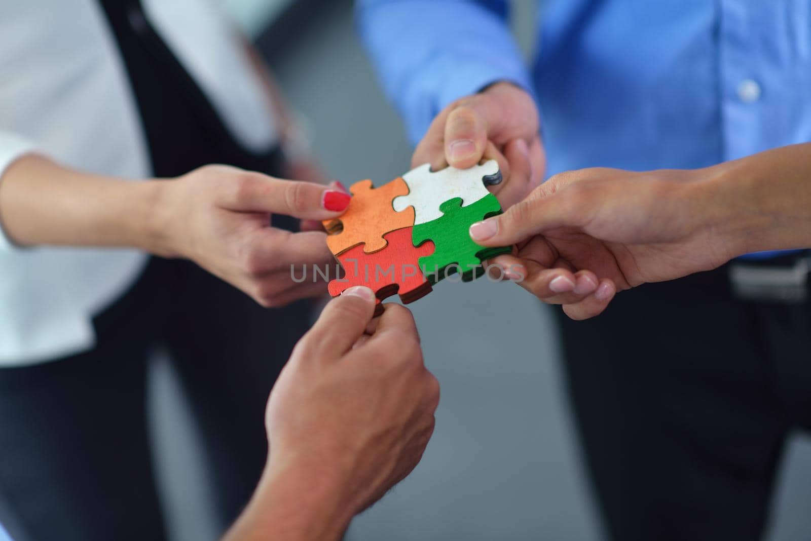 Group of business people assembling jigsaw puzzle by dotshock