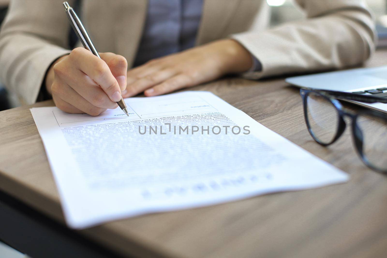 Female hand signing new important business contract. by tsyhun