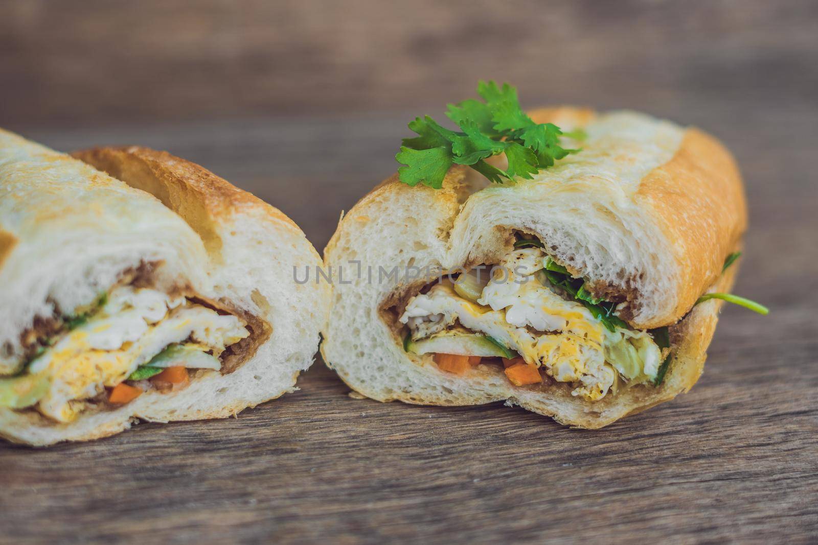 A delicious Vietnamese Bahn Mi sandwich on a wooden background.