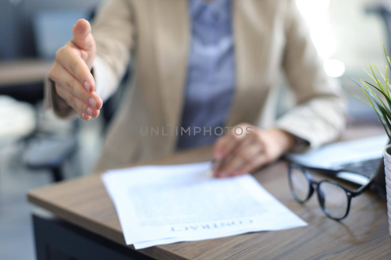 Midsection of a businesswoman with an open hand ready to seal a deal. by tsyhun