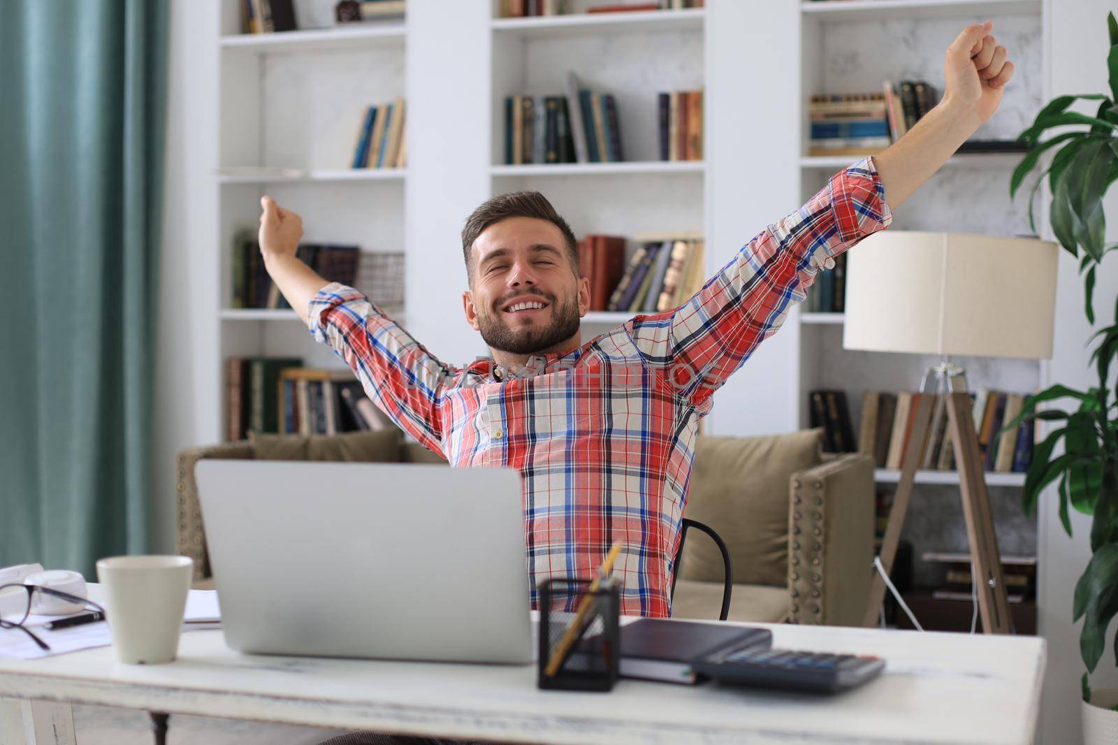 Smiling handsome businessman relaxing at home office