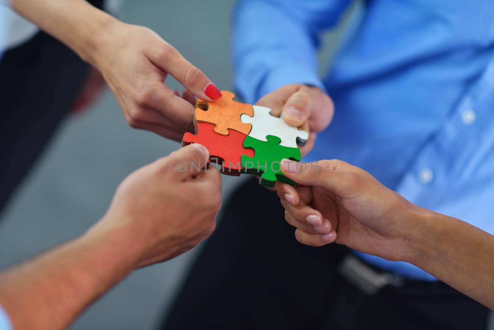 Group of business people assembling jigsaw puzzle by dotshock