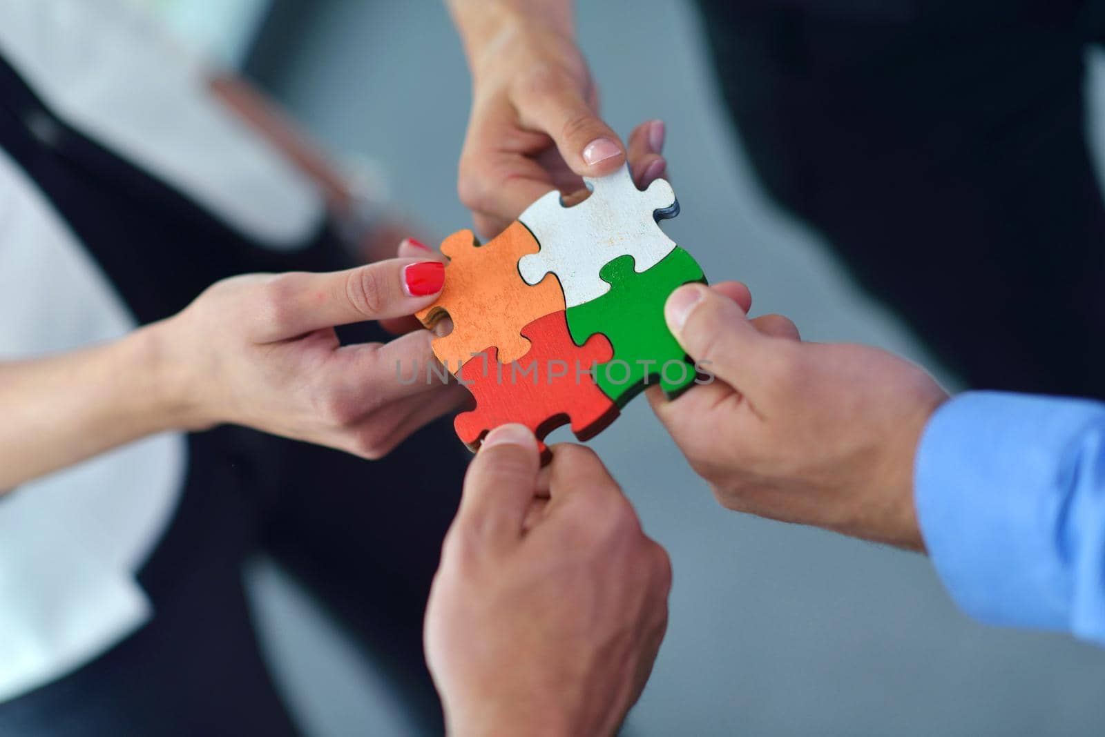 Group of business people assembling jigsaw puzzle by dotshock