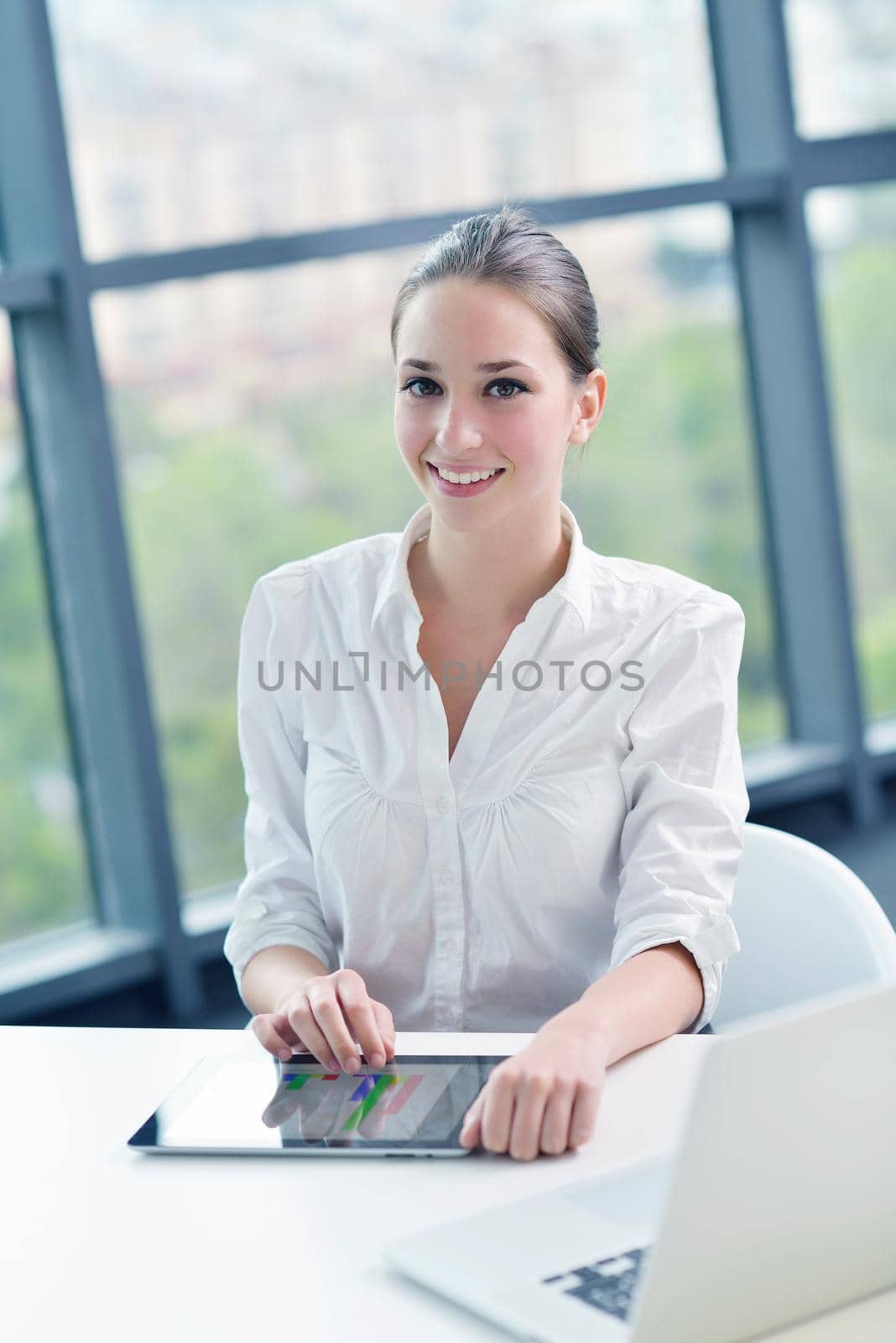 portrait of Young pretty business woman work on  notebook computer  in the bright modern office indoors