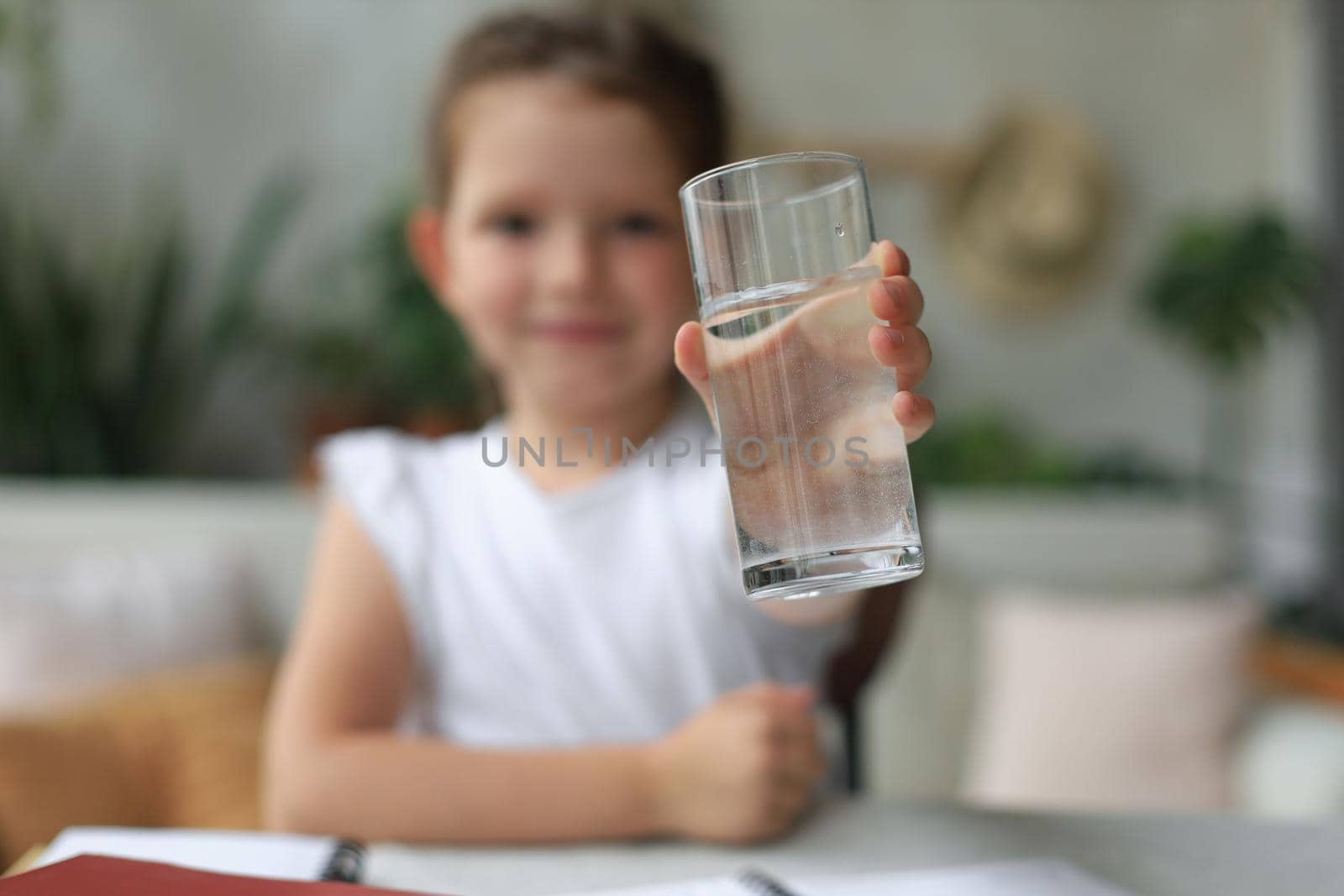 Happy little girl offer crystal still mineral water from glass, small child recommend daily dose of clean aqua. by tsyhun