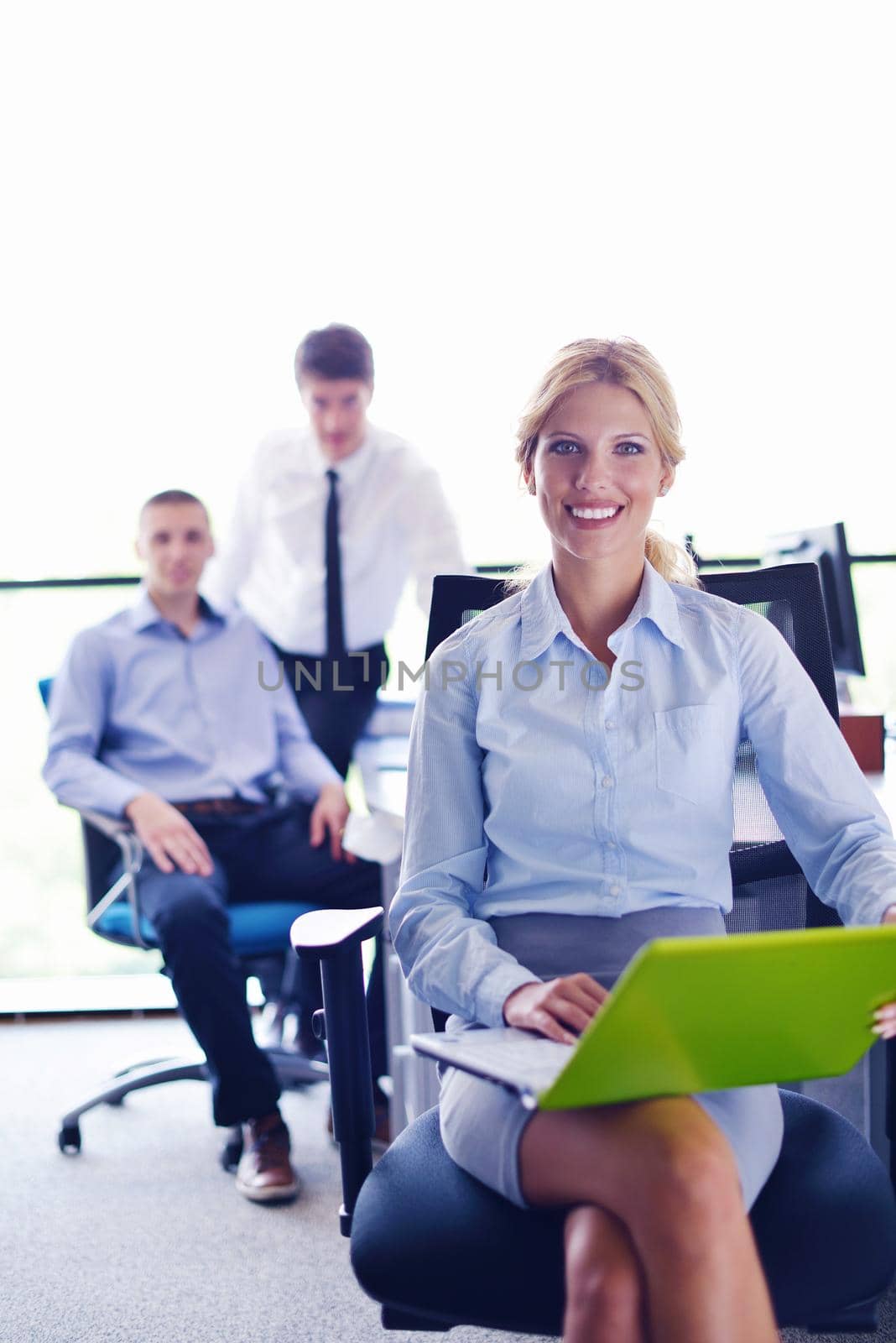 business woman with her staff in background at office by dotshock