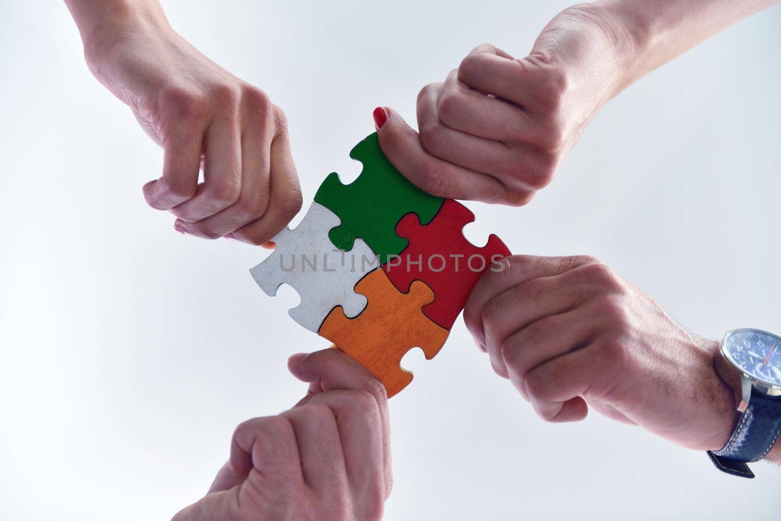 Group of business people assembling jigsaw puzzle by dotshock