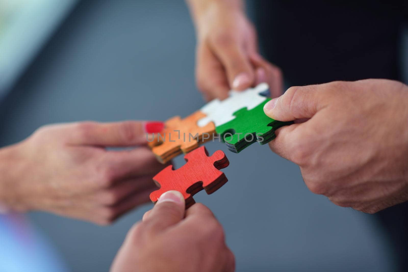 Group of business people assembling jigsaw puzzle by dotshock