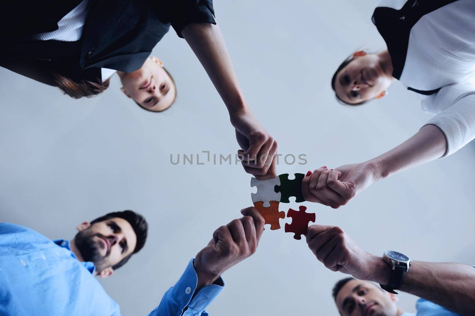 Group of business people assembling jigsaw puzzle by dotshock