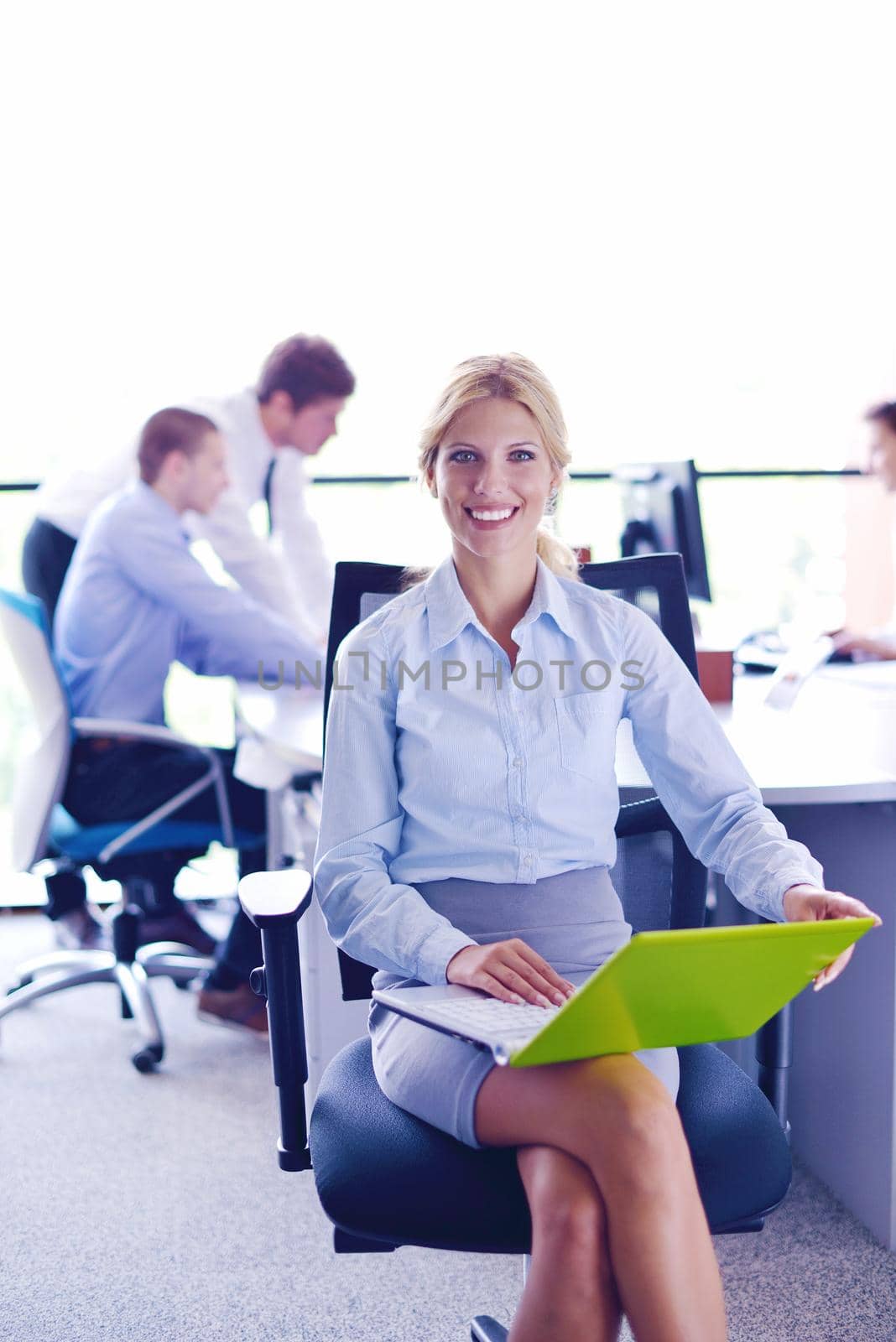 business woman with her staff in background at office by dotshock