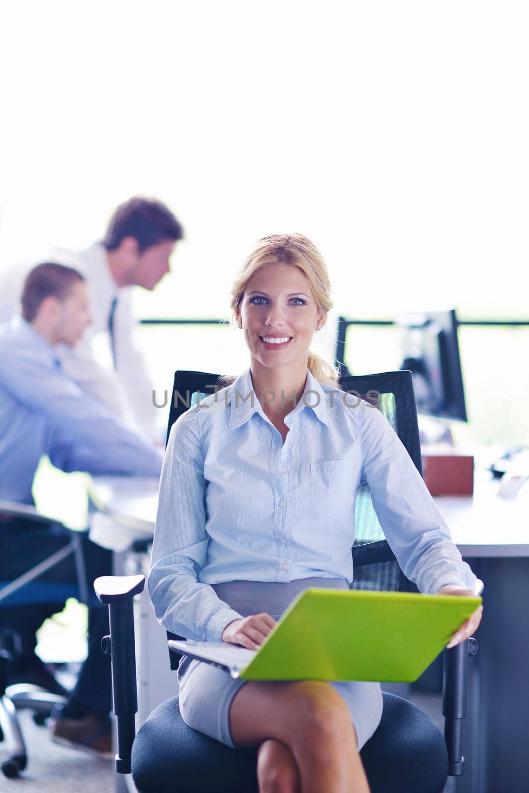 business woman with her staff in background at office by dotshock