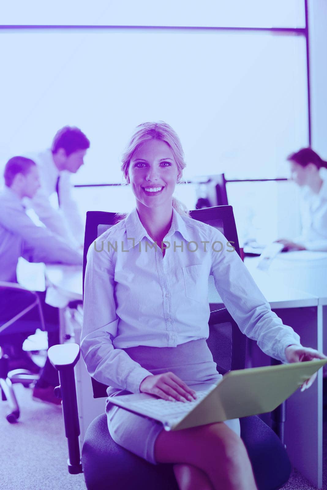 business woman with her staff in background at office by dotshock