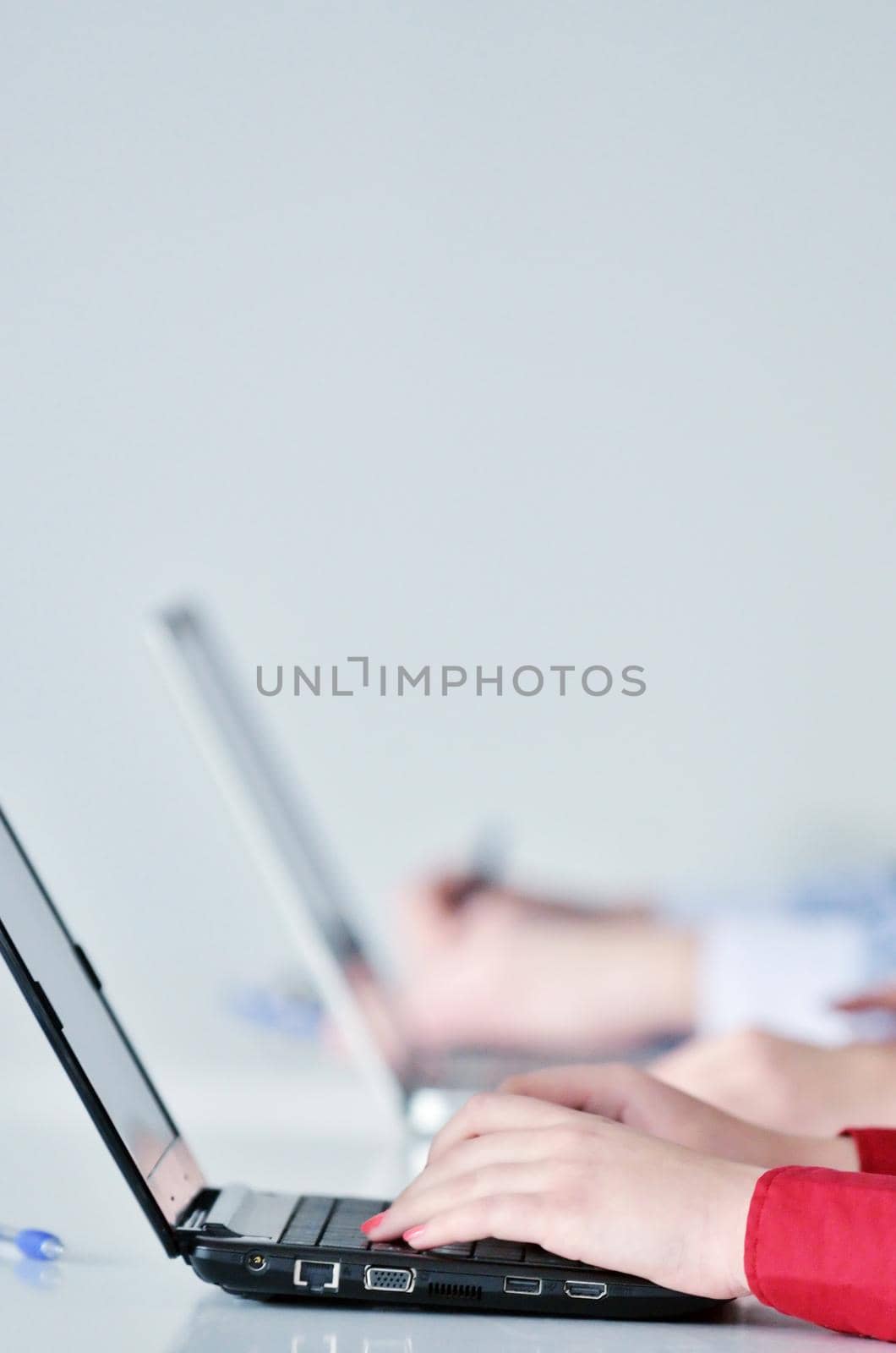 Pretty young business woman group with headphones smiling at you against white background