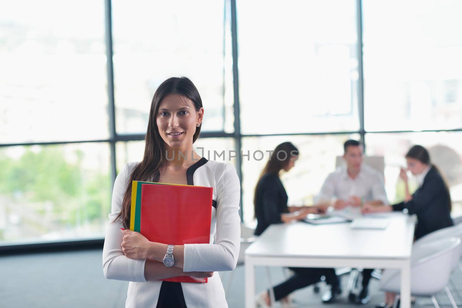 happy young business woman  with her staff,  people group in background at modern bright office indoors