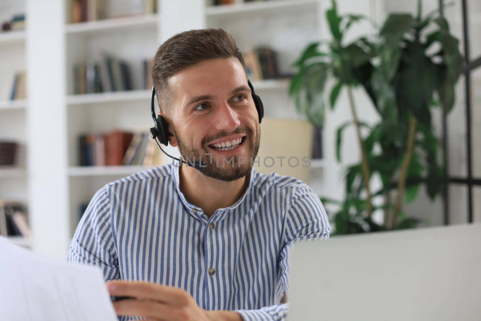 Smiling young business man having video call in office