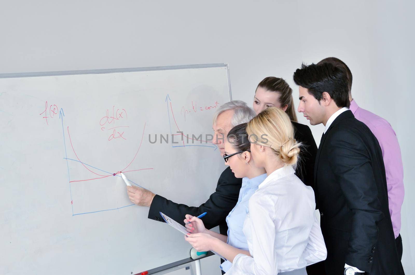 Senior male business man giving a presentation at a  meeting at modern light office on a table board